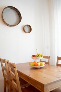 a wooden table with a bowl of fruit on it at Casa d’autore siciliana in Milan