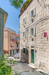 a stone building with a green door on a street at Under Constructiion in Split