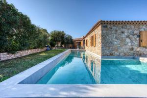 una piscina frente a una casa de piedra en Villa Stella, en Lumio