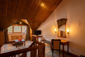 een woonkamer met een houten plafond en een spiegel bij Mastiff Grand Manali Resort in Manāli