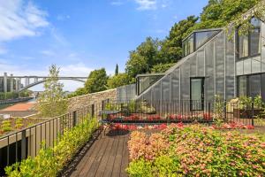 a glass house with a bench in a garden at 108MM House in Porto