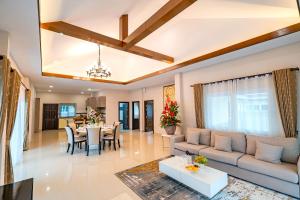 a living room with a couch and a table at Silverlake Oasis : Pool Villa in Na Jomtien