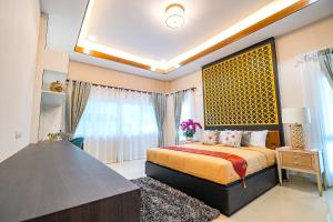a bedroom with a bed and a large window at Silverlake Oasis : Pool Villa in Na Jomtien