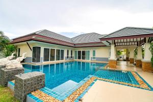 une maison avec une piscine en face de celle-ci dans l'établissement Silverlake Oasis : Pool Villa, à Na Jomtien