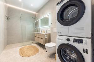 a washer and dryer in a bathroom with a toilet at 360 Apartments in Užpelkiai +38 photos