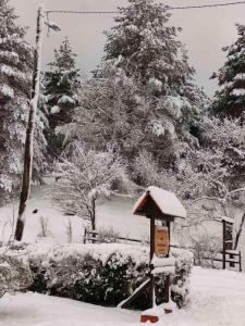 a snow covered park with a bird house and trees at Apartman Vito Saborsko in Saborsko