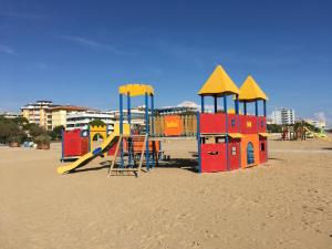 un parco giochi sulla sabbia su una spiaggia di Villaggio Azzurro Plus a Bibione