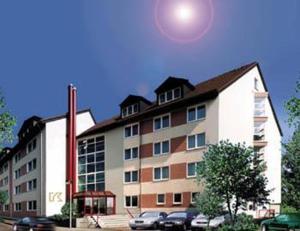 a large building with cars parked in front of it at Kempe Komfort plus Hotel in Solingen