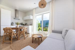 cocina y sala de estar con sofá y mesa en 360 Apartments en Užpelkiai