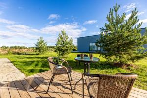 a patio with a table and chairs on a deck at 360 Apartments in Užpelkiai