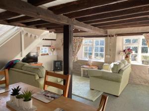 Sala de estar con 2 sofás y mesa en Chiddy Nook Cottage en Chideock