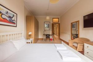 - une chambre avec un lit blanc et une télévision dans l'établissement Beautiful 2 Bed 2 Bath Flat overlooking Meadows Park, à Édimbourg