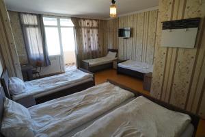 a room with three beds in it with a window at imperator 1 Hotel in Kutaisi