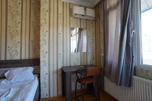 a bedroom with a desk and a bed and a window at imperator 1 Hotel in Kutaisi