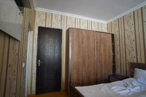 um quarto com uma cama e uma porta de madeira em imperator 1 Hotel em Kutaisi