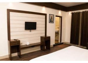 a room with a tv on a wall at Ritumbhara Hotel & Resort in Alwar