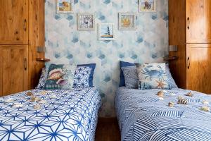 2 letti in una camera da letto con blu e bianco di Ghe Sem Morazzone B&B a Gazzada