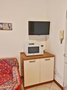 a living room with a tv and a microwave at Casa Comisso in Caorle
