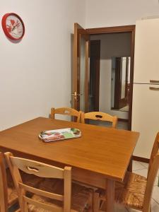 a kitchen with a wooden table with chairs and a refrigerator at Casa Comisso in Caorle