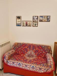 a red couch in a living room with pictures on the wall at Casa Comisso in Caorle