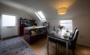 a kitchen with a table and chairs and a kitchen with a counter at Skyelight Apartment in Portree