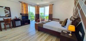 Un dormitorio con una cama y una ventana grande. en ARA Beach Resort Mirissa, en Mirissa