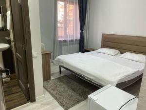 a small bedroom with a bed and a window at The Friends in Yerevan