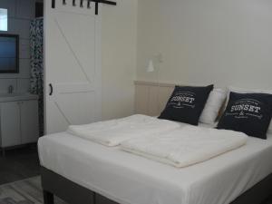 a white bed with two pillows on top of it at Strandstudio Cato, vlakbij zee! in Callantsoog