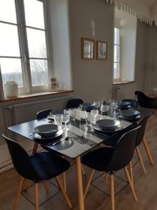 une table avec des chaises, des assiettes et des verres dans l'établissement Grand appart 150m2 dans belle maison bourgeoise, à Vernaison