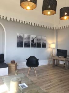 - un salon avec une chaise noire et une table dans l'établissement Grand appart 150m2 dans belle maison bourgeoise, à Vernaison