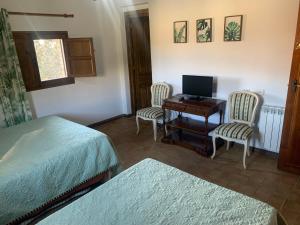 1 dormitorio con escritorio, 2 sillas y ordenador en Casa Rural Los Robles de Acebo II, en Acebo
