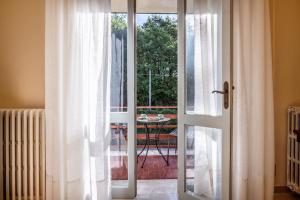 une porte coulissante en verre menant à une terrasse avec une table. dans l'établissement Appartamento Poggio del Sole, à Lucques