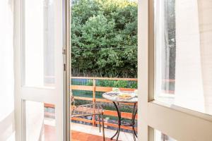 une porte en verre menant à une terrasse avec une table. dans l'établissement Appartamento Poggio del Sole, à Lucques