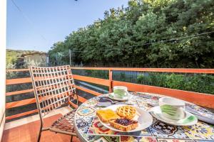 une table avec une assiette de nourriture sur un balcon dans l'établissement Appartamento Poggio del Sole, à Lucques