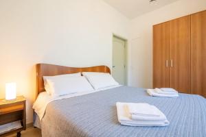 Appartamento Poggio del Sole في لوكّا: غرفة نوم عليها سرير وفوط