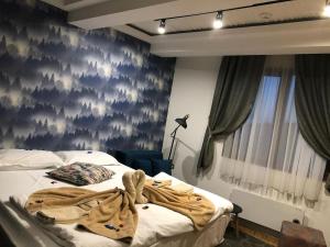 a bedroom with a bed with a blanket on it at Hotel MUJEN LUX Wellness & Spa in Kopaonik