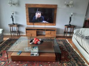 a living room with a tv and a table at Apto 5 quartos na Orla de Copacabana in Rio de Janeiro