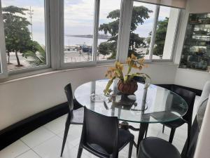 a glass table and chairs in a room with windows at Apto 5 quartos na Orla de Copacabana in Rio de Janeiro