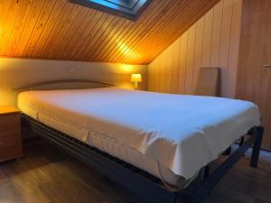 a large bed in a room with a wooden wall at Vierbarke 73 in Nieuwpoort