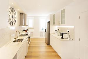 タヴィラにあるAmarela 17の白いカウンターと壁掛け時計付きのキッチン +31枚の写真