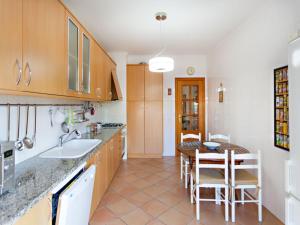 a kitchen with a sink and a table with chairs at Alameda Apartment in Faro