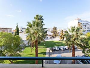a view from a balcony of a parking lot with palm trees at Alameda Apartment in Faro