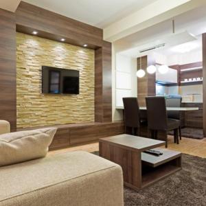 a living room with a couch and a dining room at Hotel MUJEN LUX Wellness & Spa in Kopaonik