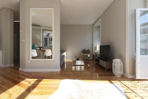 a living room with a bed and a mirror at Apartamento Andrade in Lisbon