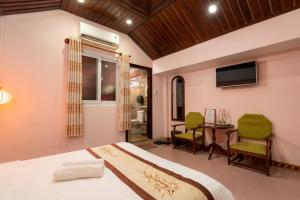 a bedroom with a bed and a table and chairs at Hoa My II Hotel in Hoi An