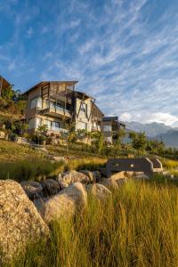 una casa in cima a una collina con alcune rocce di Norbu The Montanna, Dharamshala - IHCL SeleQtions a Dharamshala