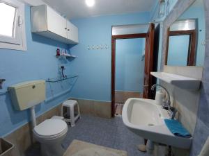 a blue bathroom with a toilet and a sink at Kalderimi "Olive Green" House in Promírion