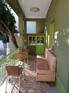 a porch with a couch and a table on a balcony at Kalderimi "Olive Green" House in Promírion