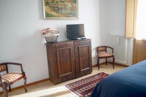 A television and/or entertainment centre at La Casa Altrui- Camere e Zona relax con Giardino