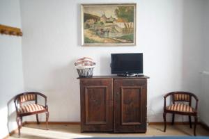 A television and/or entertainment centre at La Casa Altrui- Camere e Zona relax con Giardino